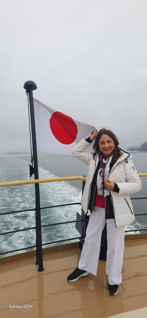 Person posing with a Japanese flag on a ferry.
