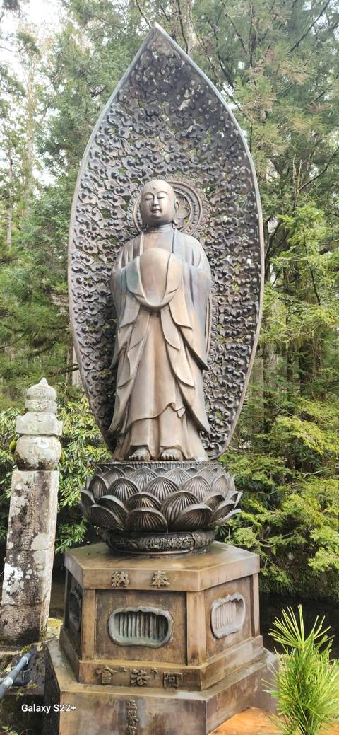 Buddha statue in a lush garden setting.