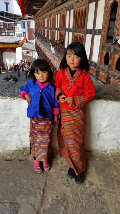       Two children in traditional clothing standing side by side.
  