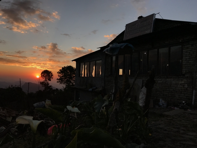       Sunset view through a guest house window with mountains outside.
  