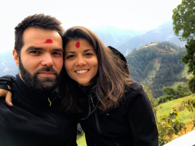       Close-up portrait of a couple with red tilak on their foreheads.
  