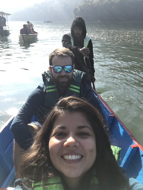       Close-up selfie of a couple rowing a boat on a lake.
  