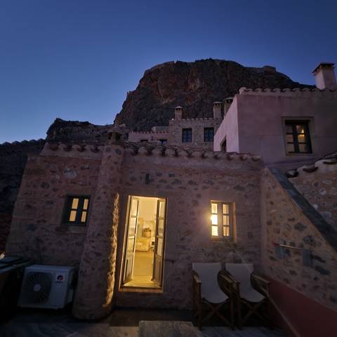       Evening view of a rock house with warm lights.
  