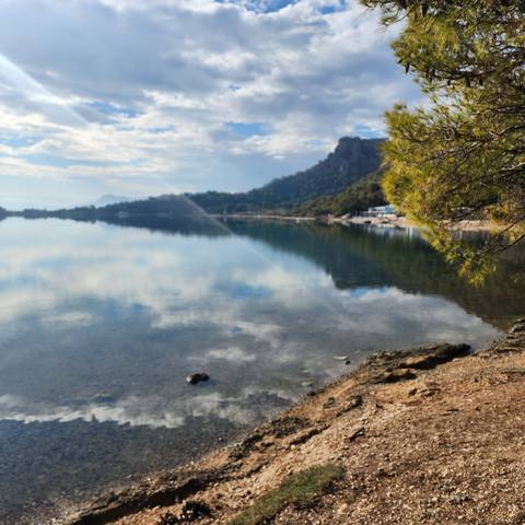 A serene lake with reflections and hills.