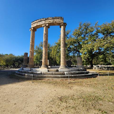 Ruins with ancient columns surrounded by trees.