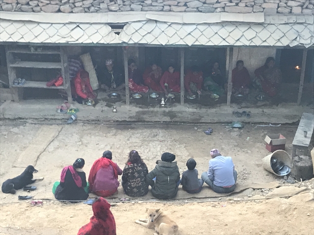       People sitting in a row inside a building.
  