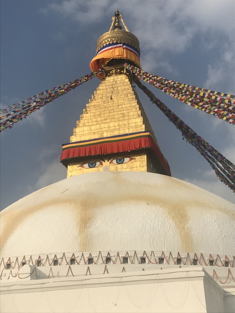       Buddhist stupa with prayer flags and eyes motif.
  