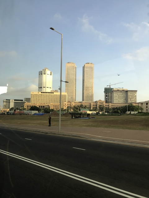 Modern cityscape with tall buildings and green space.