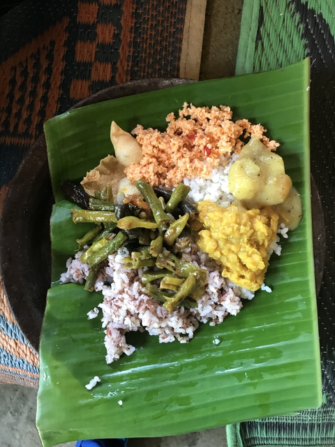      Traditional meal served on a banana leaf with a variety of dishes.
  