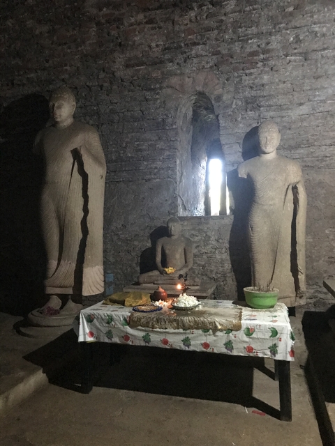 Buddhist statues in a dimly lit cave setting.