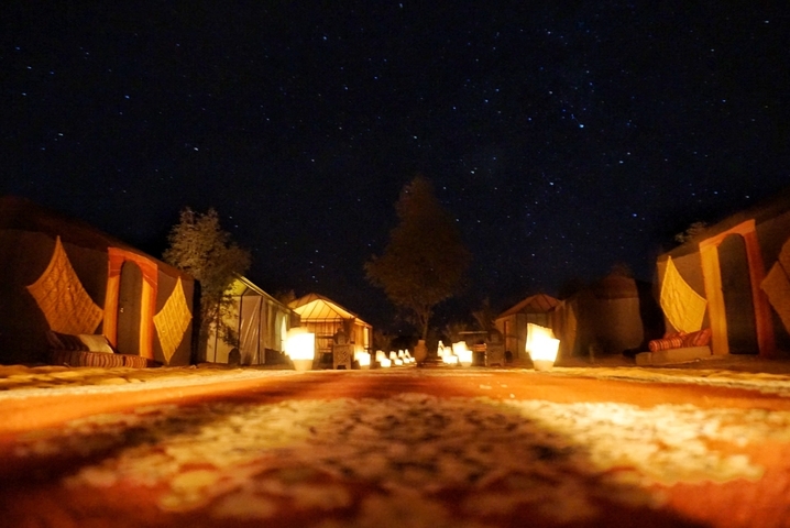Lit walkway with stars visible in the night sky above.