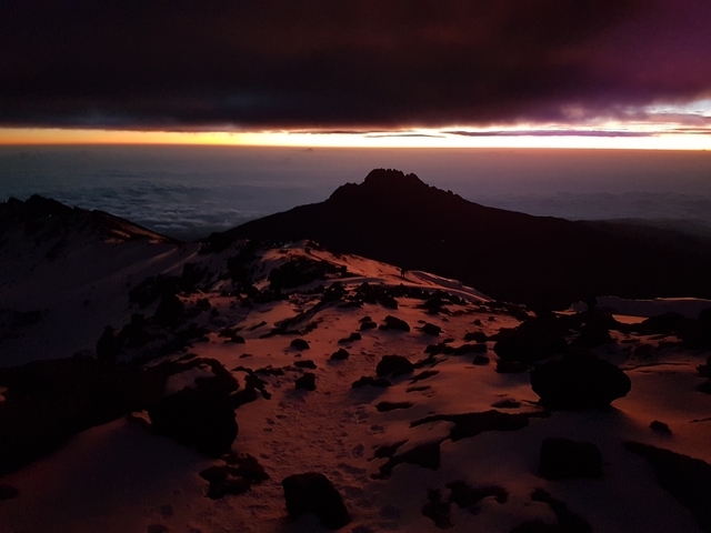 Orange sunset over a snowy mountain landscape.