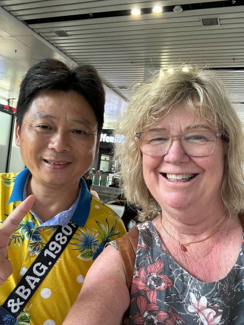 Two people smiling indoors, appearing close to the camera.