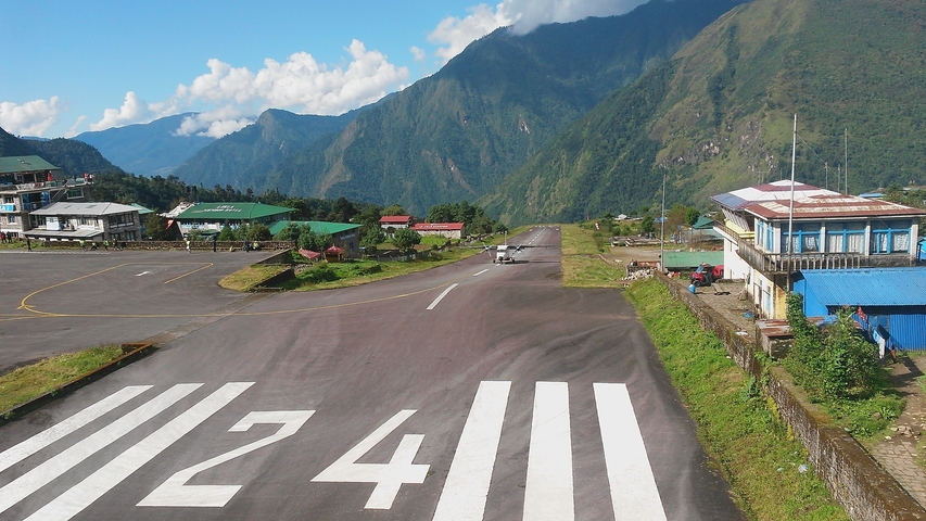 Aeroplane runway surrounded by mountains.