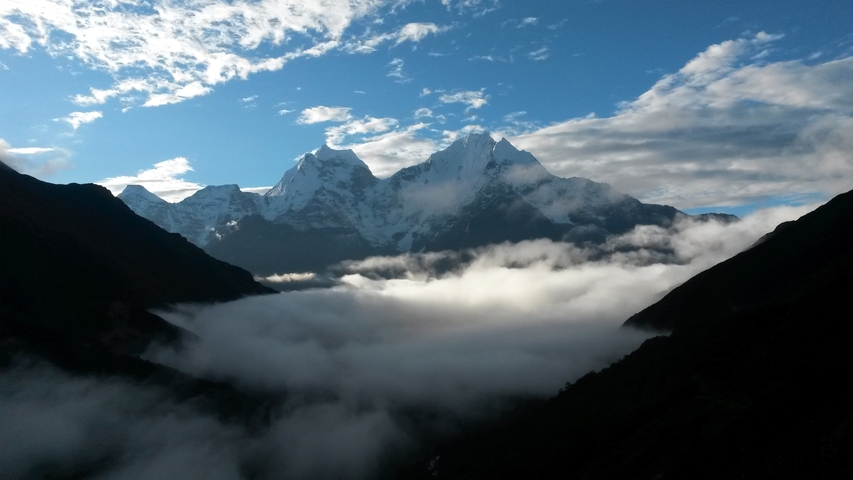       Sunrise over mountain peaks and misty clouds.
  