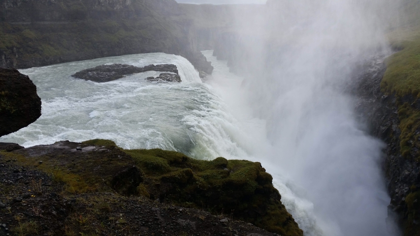       Powerful flowing waterfall surrounded by mist.
  