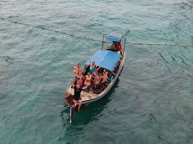 Group of people on a small boat waving.