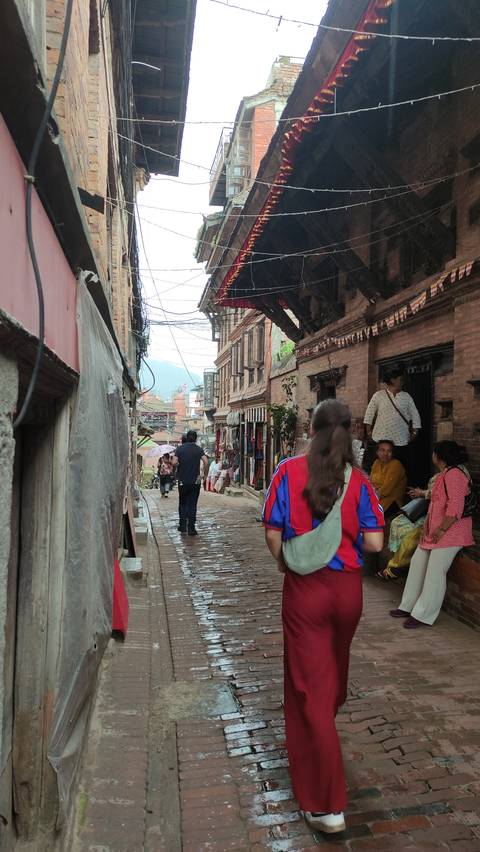 A bustling street scene with people walking and buildings.