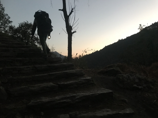 Person climbing stone steps during early evening.