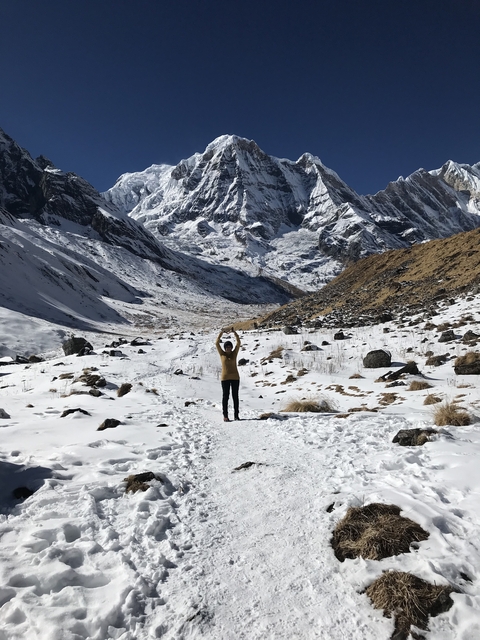       Person standing in a snowy mountainous landscape.
  