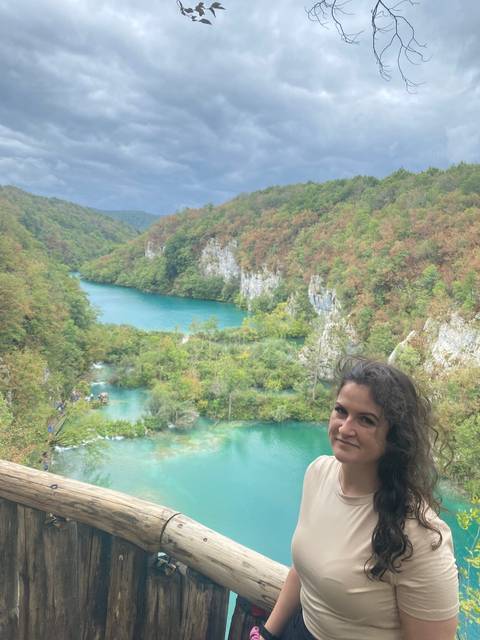       A woman overlooking a scenic waterfall and river.
  