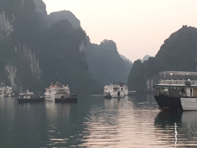 Blurred image of boats in Halong Bay at dusk.