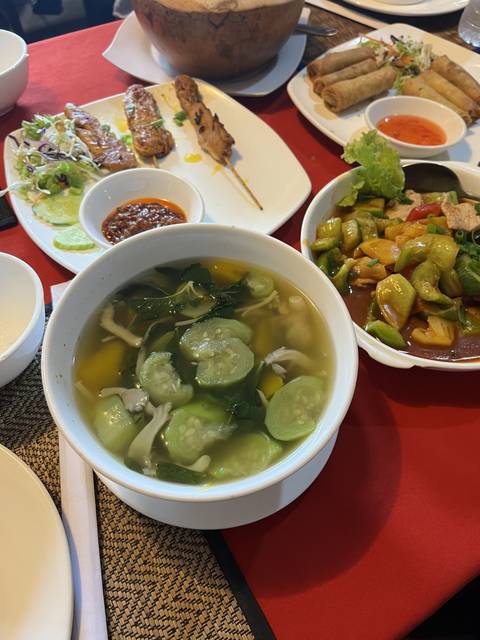       Various dishes with soup and cooked vegetables on a table.
  