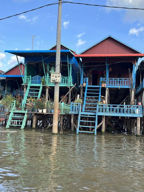       Colorful stilt house along the water.
  