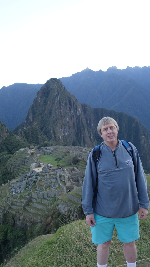 A person posing with Machu Picchu in the background.