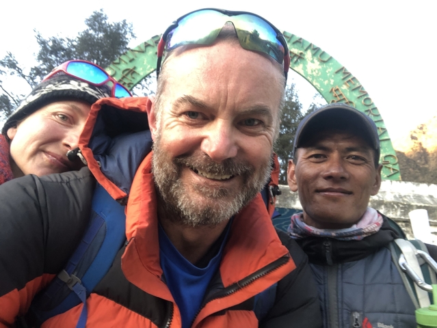 Close-up selfie of three people smiling outdoors.