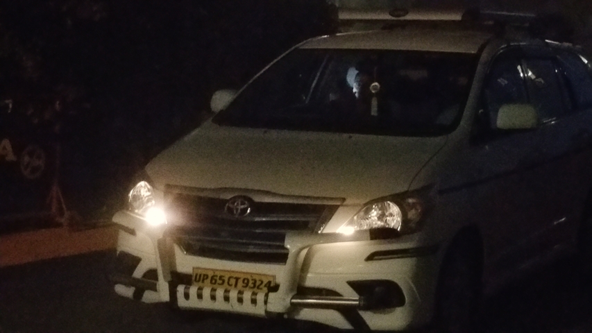 Car driving at night with headlights on.