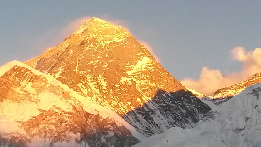 Illuminated mountain peak under a serene sky.