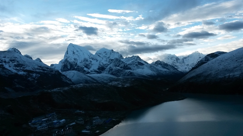 Panoramic view of a mountain range with a serene lake.