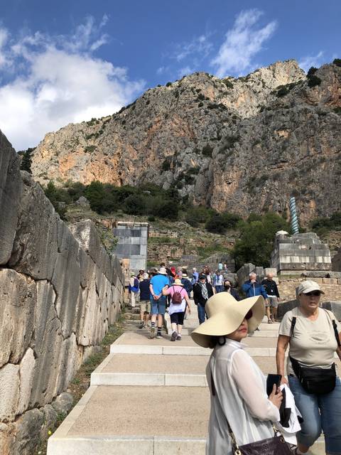 Tourists walking on ancient stone steps outside.