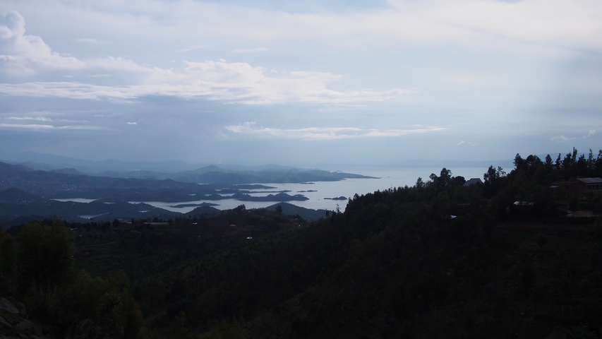       Mountain and lake view under cloudy sky.
  