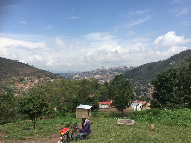       Cityscape with distant skyline and green hills.
  