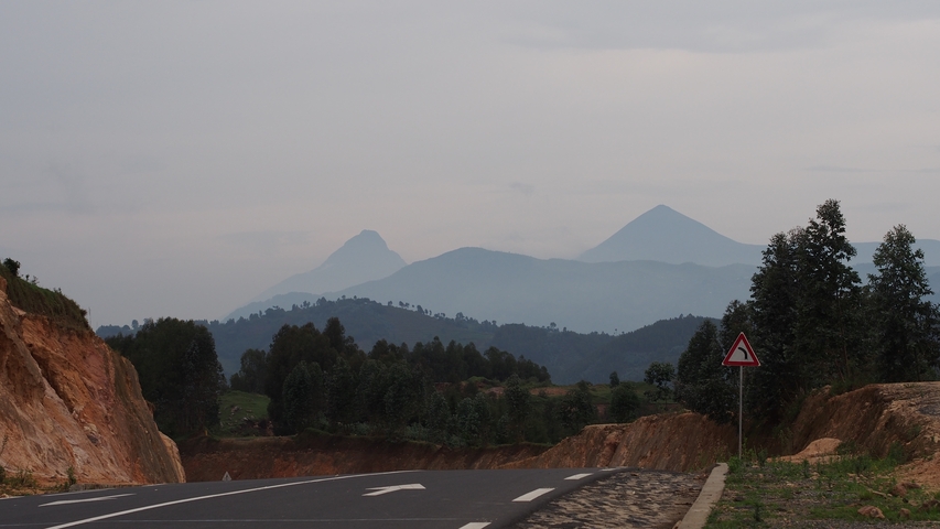      Scenic view of winding mountain road with sign.
  