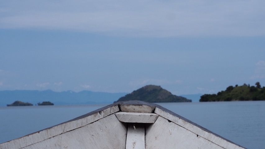       Boat on lake with distant mountains.
  