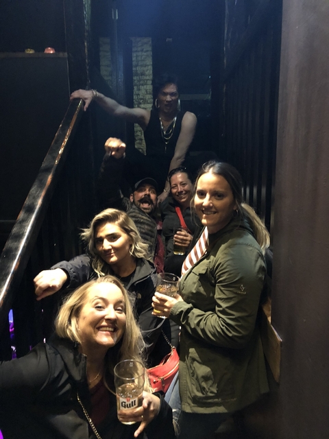Group of people inside a building with drinks.