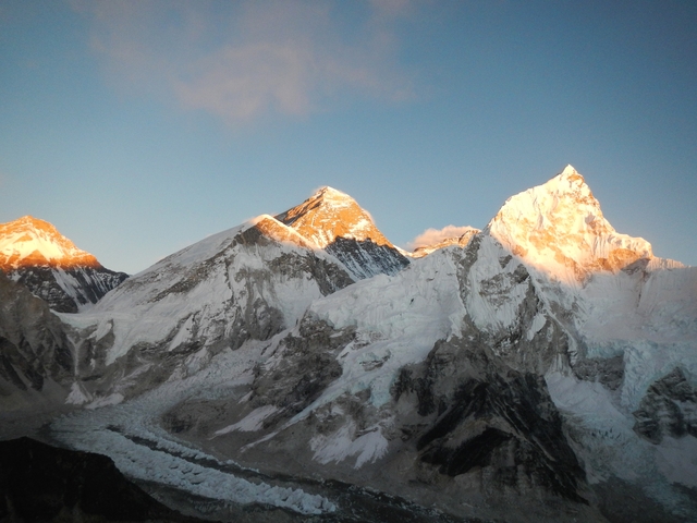High peaks of mountains at sunrise glowing orange in the sunlight.