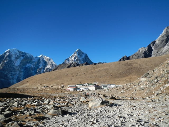 Small settlement in a mountain valley under clear blue sky.