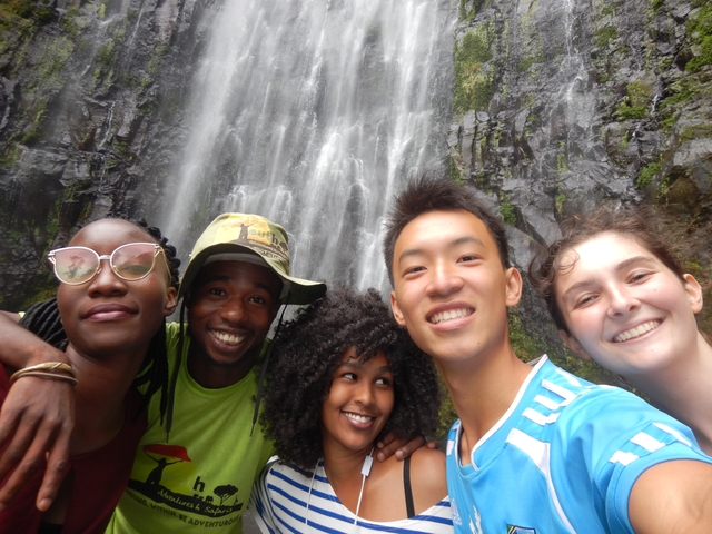       Group selfie in front of a waterfall.
  