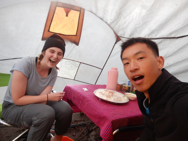       Two people enjoying a meal inside a tent.
  