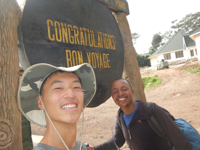       Two people smiling in front of a 'Congratulations Bon Voyage' sign.
  