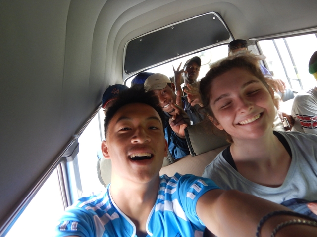       Group of smiling people inside a vehicle.
  
