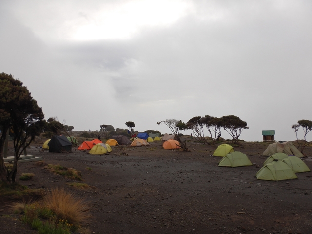       Tents pitched at a campsite with a cloudy sky.
  