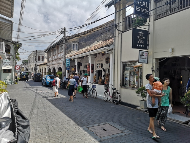       Busy street with tourists and shops in a historic town.
  
