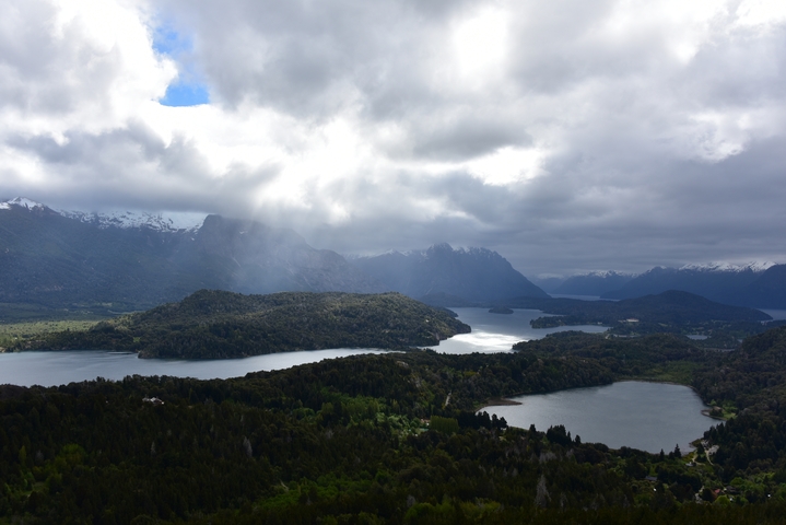       Scenic aerial view of lakes and mountains with dramatic clouds.
  