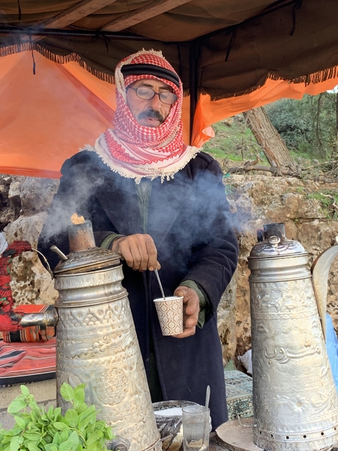 Person making tea using traditional kettles.