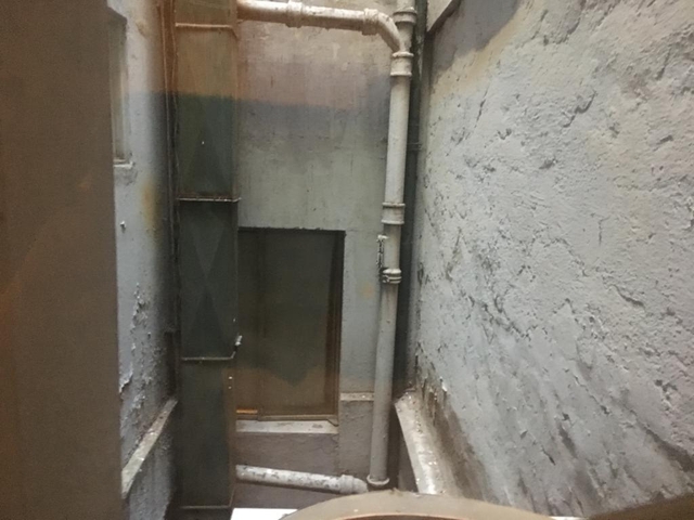 View of a narrow alley with pipes.